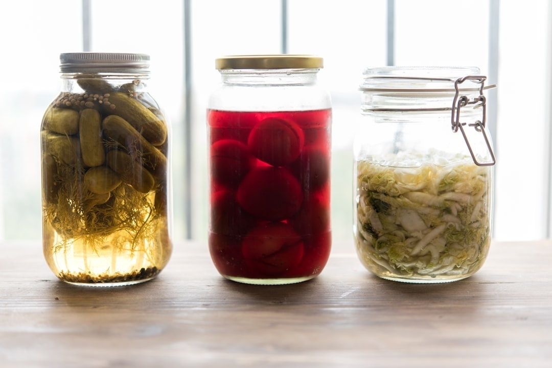 Drie glazen potten met gefermenteerde komkommers, bieten en kool